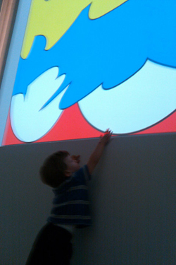 A child reaching up to one of Adi Da's art works